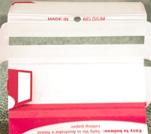A pack of Tally-Ho rolling papers with the cardboard unfolded completely, revealing the text "Made in Belgium" printed on the inside.