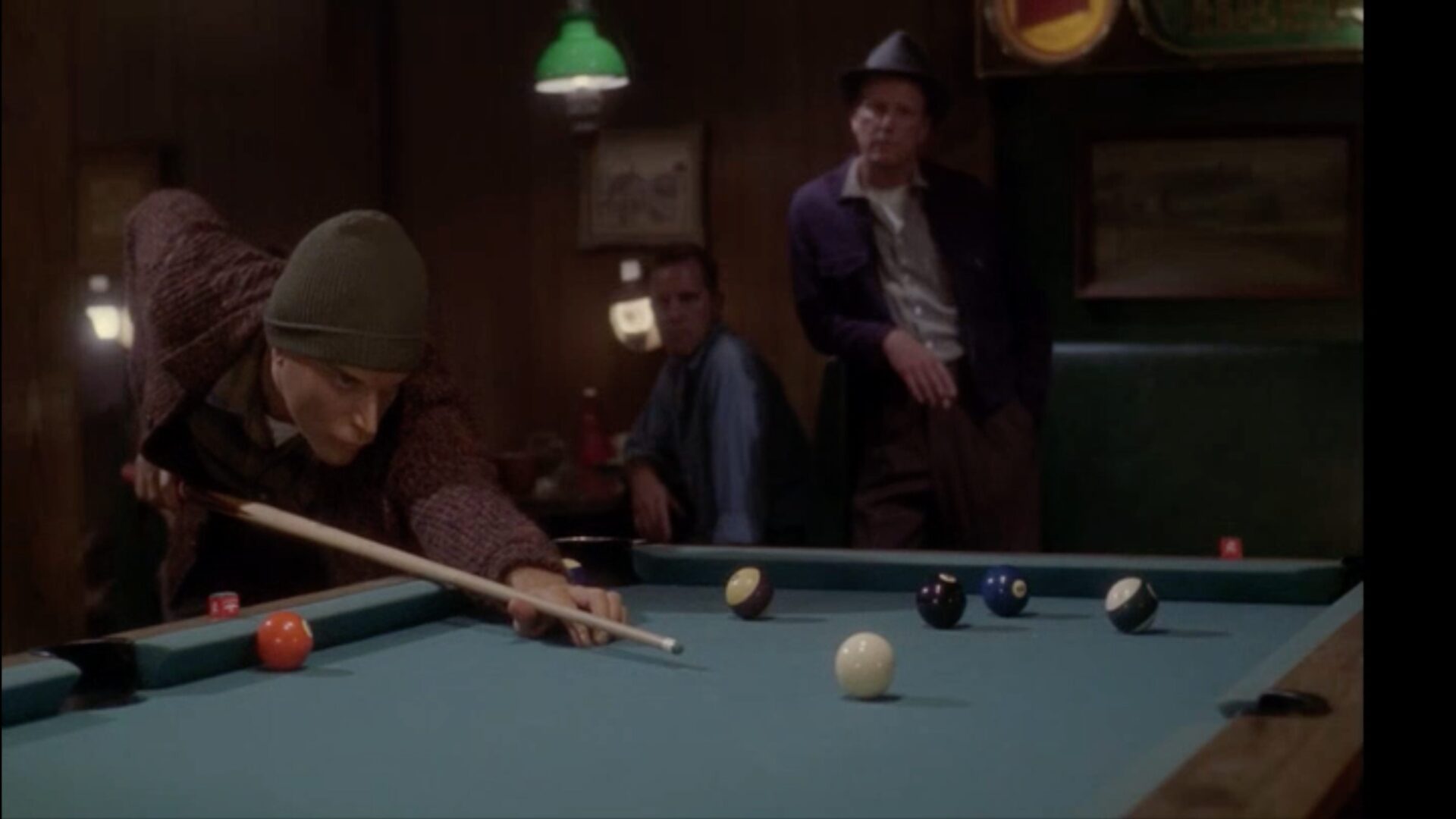 Mestral, a Vulcan wearing a beanie, playing a game of pool in a bar on Earth